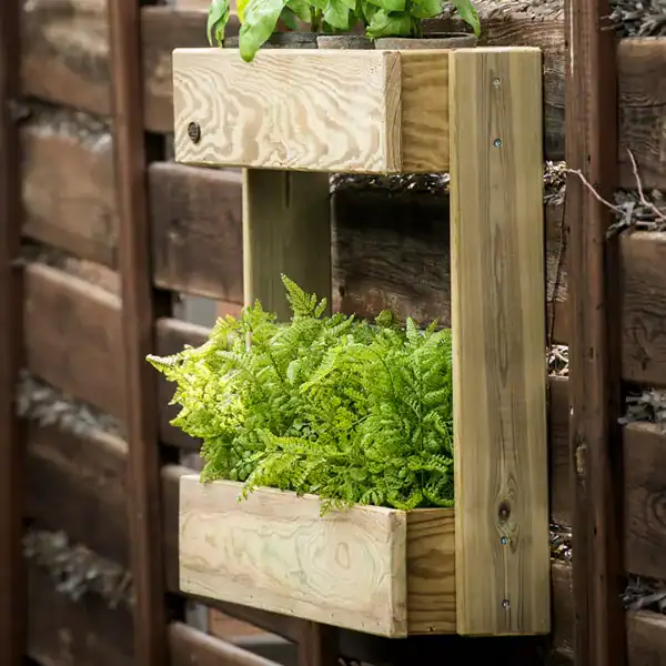 Huerto en olla de madera para cultivo ecológico en jardín exterior.