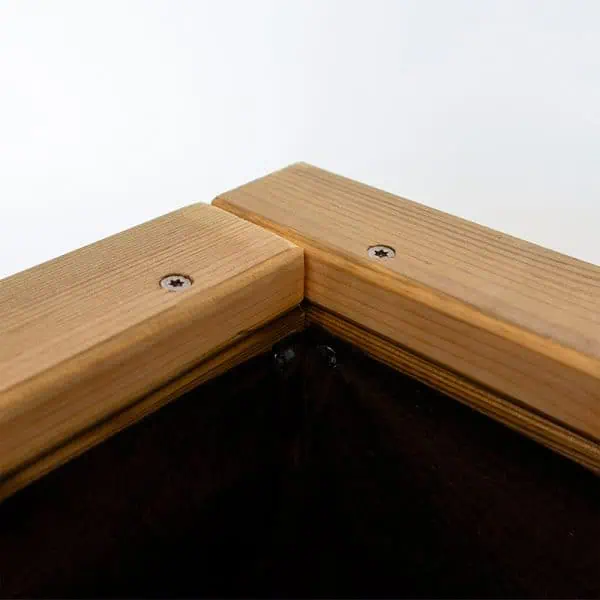 Borde de madera natural para huerto urbano o jardín sostenible, con tornillos visibles, diseñado para protección y durabilidad.