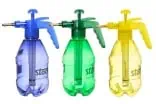 Botellas de pulverizador de plástico con aspersores en colores azul, verde y amarillo para jardinería y huerto, ideales para cultivos ecológicos y técnicas de riego sostenibles.