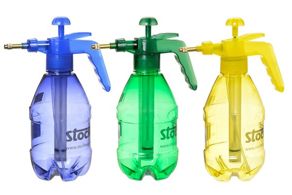Botellas de pulverizador de plástico con aspersores en colores azul, verde y amarillo para jardinería y huerto, ideales para cultivos ecológicos y técnicas de riego sostenibles.