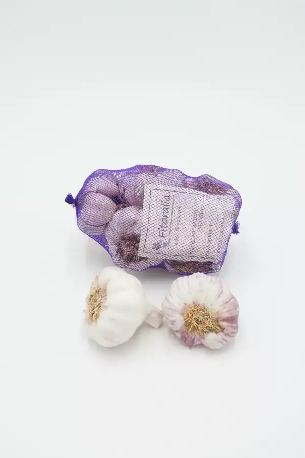 Ajos orgánicos de cosecha ecológica en malla morada para venta y consumo saludable en huerto.bio.